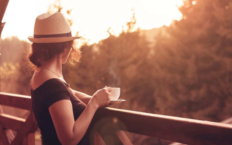woman having coffee on balcony in summer